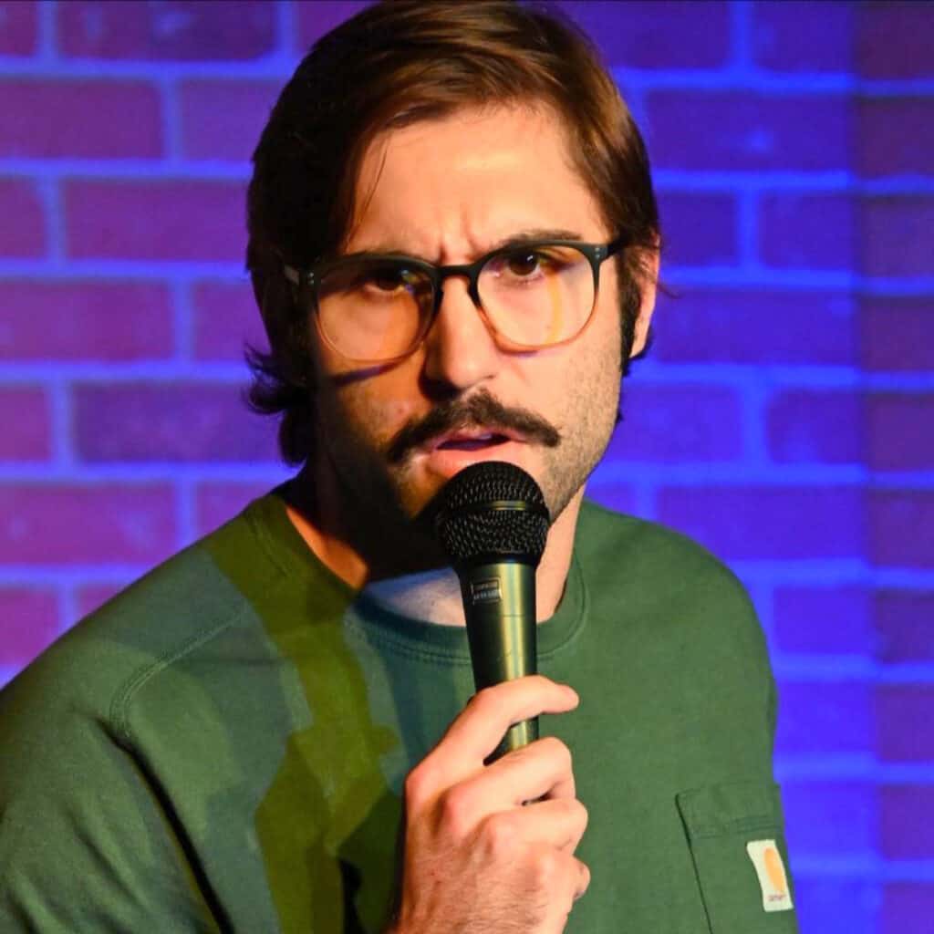 Aaron Heltz performing stand-up comedy during a live show in Louisiana
